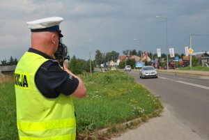 policjant podczas mierzenia prędkości jazdy