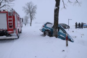 miejsce wypadku drogowego na trasie Trygort-Przystań. Po lewej stronie pojazd służbowy straży pożarnej, po prawej stronie uszkodzony pojazd seat