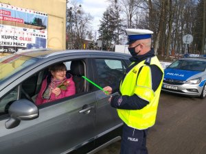 Policjant wręczający kwiaty kierowcy