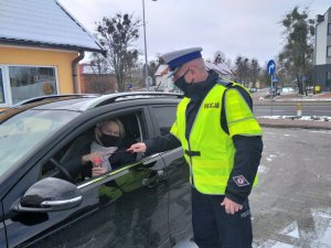 Policjant wręczający kwiaty kierowcy