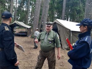 z prawej strony Policjant z lewej Strażak podczas rozmowy z komendantem obozu