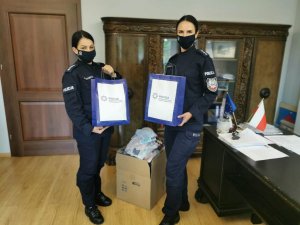 Policjantki podczas przekazania nakryć  głowy w Biurze Rady Miejskiej w Węgorzewie