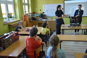 policjantka prezentująca zawartość walizki technika kryminalistycznego