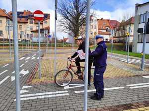 policjant podczas egzaminowani ucznia na miasteczku rowerowym