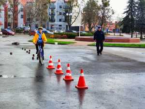 policjant podczas egzaminowani ucznia na torze rowerowym