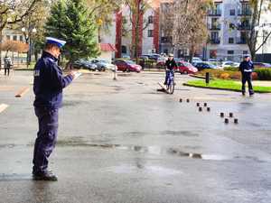 policjant podczas egzaminowani ucznia na torze rowerowym