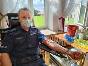 policjant w trakcie oddania krwi