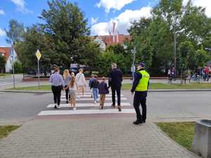 policjant przy przejściu dla pieszych wraz z uczniami