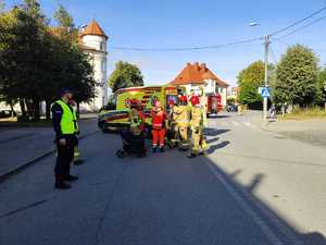 policjant, strażacy, wózek w rejonie przejścia dla pieszych
