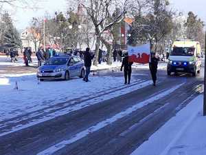 z lewej strony radiowóz a z prawej uczestnicy biegów