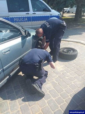 policjanci podczas wymiany koła