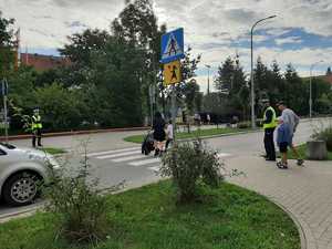 w tle policjanci z uczestnikami ruchu drogowego w trakcie działań Bezpieczna droga do szkoły