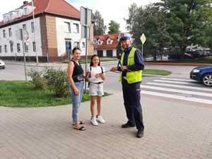 w tle policjanci z uczestnikami ruchu drogowego w trakcie działań Bezpieczna droga do szkoły