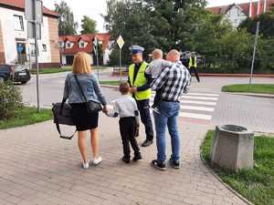 w tle policjanci z uczestnikami ruchu drogowego w trakcie działań Bezpieczna droga do szkoły