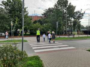 w tle policjanci z uczestnikami ruchu drogowego w trakcie działań Bezpieczna droga do szkoły