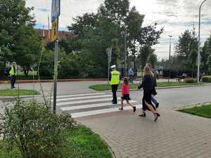 w tle policjanci z uczestnikami ruchu drogowego w trakcie działań Bezpieczna droga do szkoły