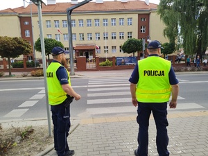 w tle policjanci z uczestnikami ruchu drogowego w trakcie działań Bezpieczna droga do szkoły