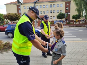 w tle policjanci z uczestnikami ruchu drogowego w trakcie działań Bezpieczna droga do szkoły